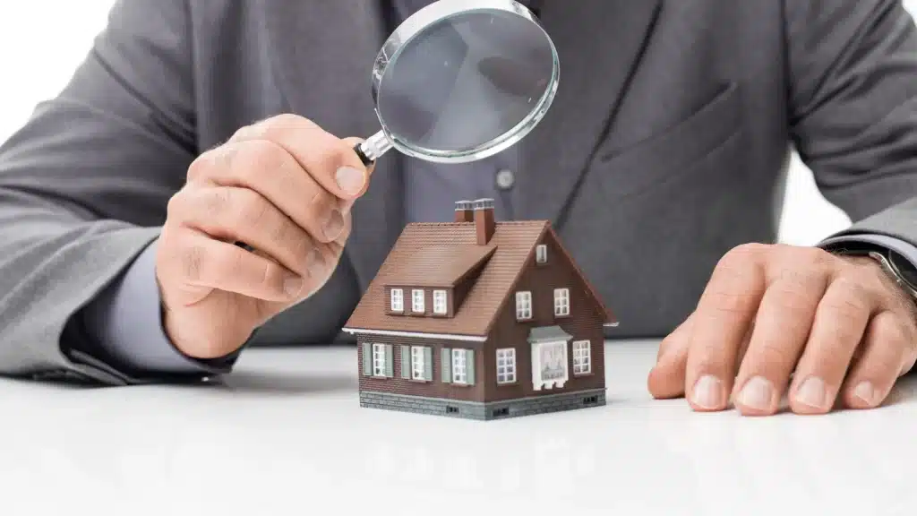Diagnostics obligatoires - homme inspectant une maison avec une loupe